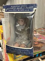 Front view of boxed musical porcelain doll