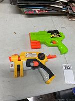 Both blasters together on table for size and type reference