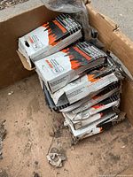 Stack of white and orange boxed chainsaw chains inside larger carton