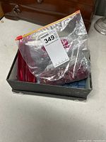Box holding zip bag of red tiles, bag of black tiles and loose blue tiles