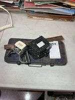 All items grouped: metal socket case, adjustable square, tape measure, two circuit breakers