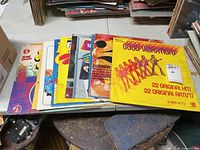Stack of ten vintage compilation LPs on table