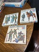 Front view of all three Tamiya Military Miniatures kit boxes on table