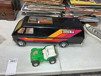 Black Tonka van and green jeep on table