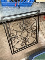 Front view of rectangular black metal scrollwork panel