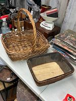 Large handled wicker basket and smaller lined basket on table