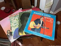 Four LP jackets displayed fanned on table