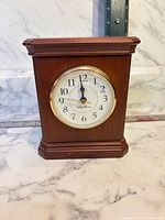 Front view of wood cased Seth Thomas mantel clock showing dial and bezel