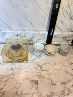 Front view of three loose teacups and boxed teacup candle gift set