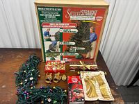 Full lot showing boxed tree stand, lights, bells, figurines, plaque, ribbon, light controller