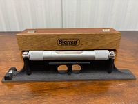 Level mounted in cast iron base with wooden case behind