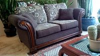 Full view of loveseat showing patterned upholstery, wood trim, and cushions