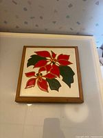 Front view showing poinsettia tile in wood frame