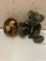 Green teddy bear and brown hedgehog plush toys side by side