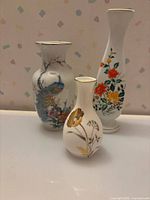 Group shot of three porcelain bud vases displaying size and design variety
