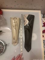 Front view of both Hilborn wall pocket vases with tape measure for scale