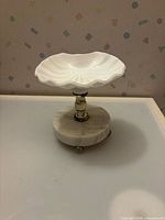 Front view of compote showing bowl, stem, marble base, and feet