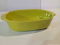 Green oval CorningWare stoneware baking dish, side handles visible