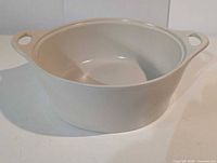 Ivory CorningWare round stoneware casserole dish without lid, showing handles and interior
