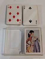 Two sample cards showing fronts; open plastic case with card back featuring Spanish lady