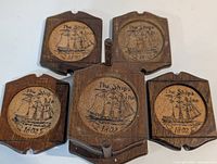 five coasters displayed with holder, showing ship motif
