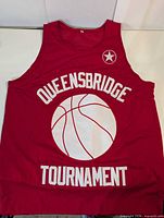 Front view of red mesh jersey showing Queensbridge Tournament graphic