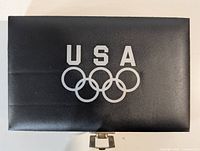 closed black case with silver USA Olympic rings logo