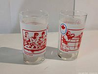 Two glass tumblers side by side showing rowing and boxing illustrations with maple leaf Olympic logo