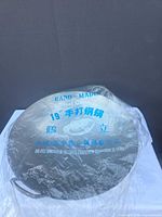 Wok wrapped in plastic showing printed hand-made 19" labeling