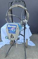 Front view of Graco Magnum XR7 sprayer on cart with hose