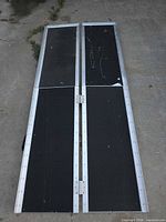Ramp unfolded showing black grip surface and hinge