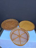 Overall view of three round trays showing different weaves and colors