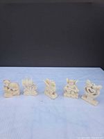 Front view of all five miniature cream figurines in a row
