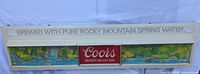 Front full view of Coors waterfall lighted sign showing header text and landscape artwork