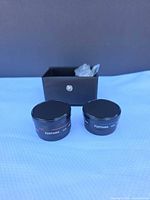 Front view of both Fujiyama auxiliary lenses with caps, case in background