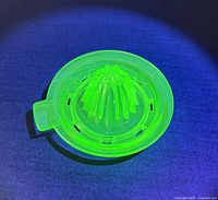 Juicer glowing under UV light highlighting uranium glass fluorescence