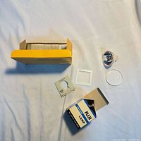 All items laid out: Kodak box with mounts, Fuji bulb box, halogen bulb, plastic cap, loose mounts