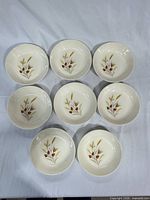 Overhead view of eight matching wheat-pattern porcelain bowls