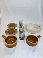 Full set front view showing bowls, plates, glasses, casserole with lid
