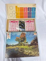 Open Parker Bingo box showing bingo cards, black chips, numbered tokens and Milton Bradley 1500-piece puzzle box beneath