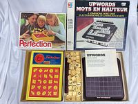 Perfection and Upwords boxes with opened game boards and components