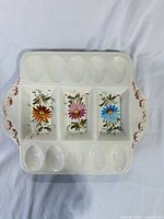 Front view showing 12 egg wells, 3 floral compartments, red-trimmed handles
