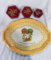Front view of tray and three hexagonal tins showing designs and colours