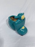 Front angled view showing teal scooter shape, yellow accents, interior opening