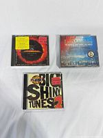 Front view of the three sealed CDs showing cover artwork