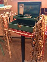 Teal vintage two-tier jewelry box on stand with jewelry hanging