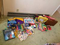 Wide view of the assortment of puzzles, games, art supplies, and children's books arranged on carpet with Backgammon board visible