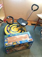 Photo showing Bumper Car Blitz yellow and blue ride-on toy with black seat and handles, Taiyo Edge Hovercraft boxed below.
