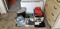 Full view of box contents showing two paper shredders, various binders, folders, boxes of tabs, and office supplies.