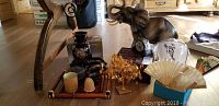 Photo showing the entire lot including large elephant figurine, bamboo tray with cups and coasters, metal leaf tree, and several folded fans.